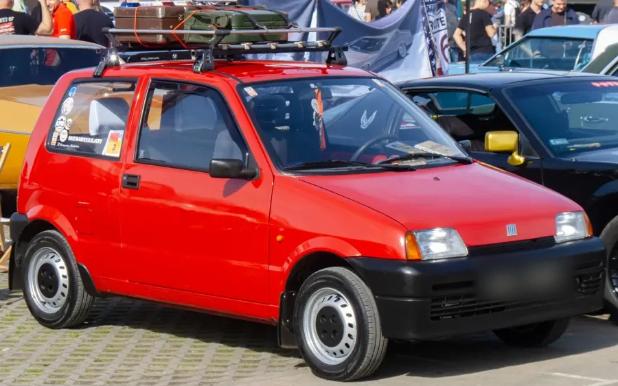 Czerwony Fiat Cinquecento z bagażnikiem dachowym na zlocie klasyków
