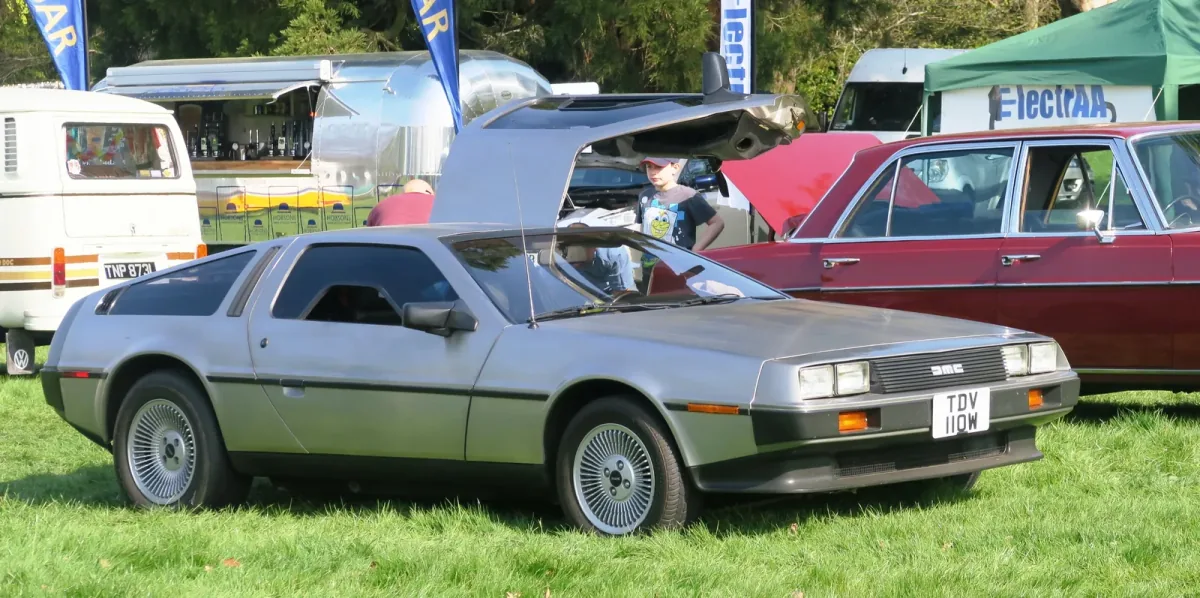 DeLorean DMC-12 z rocznika 1981 z jednym skrzydłem uniesionym w górę. Nielakierowana stal nierdzewna i drzwi otwierane jak u mewy — dokładnie ten obraz kazał twórcom „Powrotu do przyszłości" wybrać właśnie to auto.