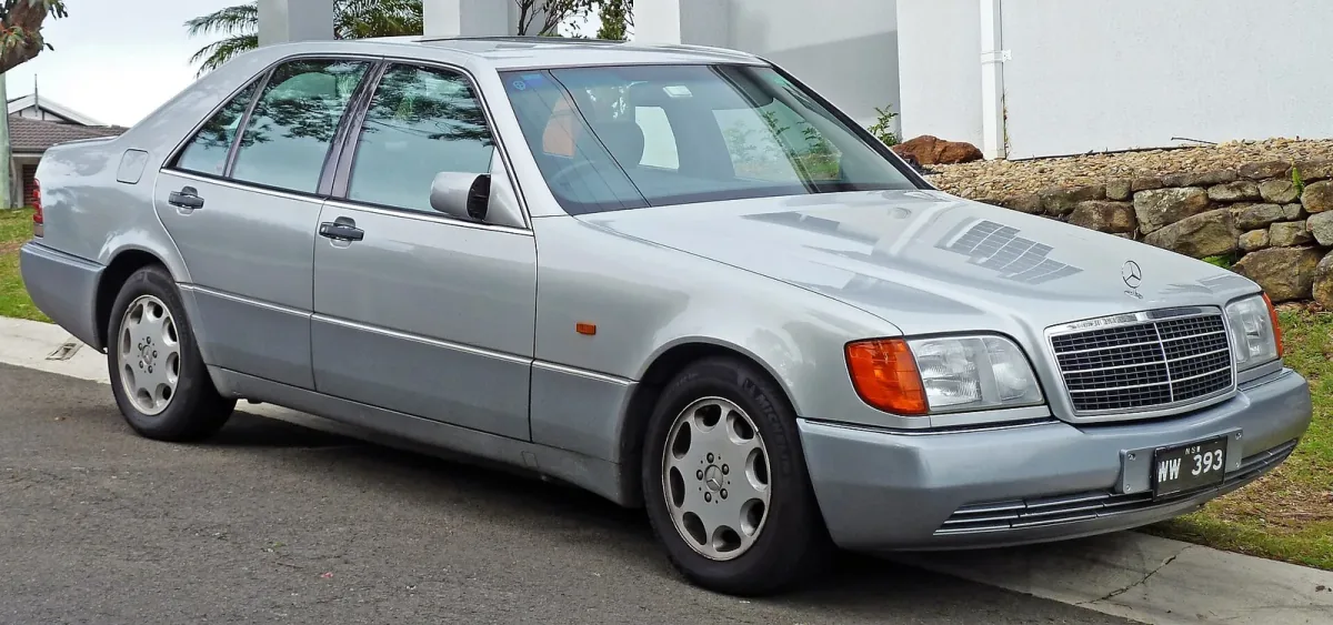 Mercedes 300 SE z pierwszych roczników — jeszcze z szarymi listwami i pomarańczowymi kierunkowskazami, które zniknęły po liftingu 1994 roku. W tej formie W140 debiutował w Genewie i wywołał burzę.