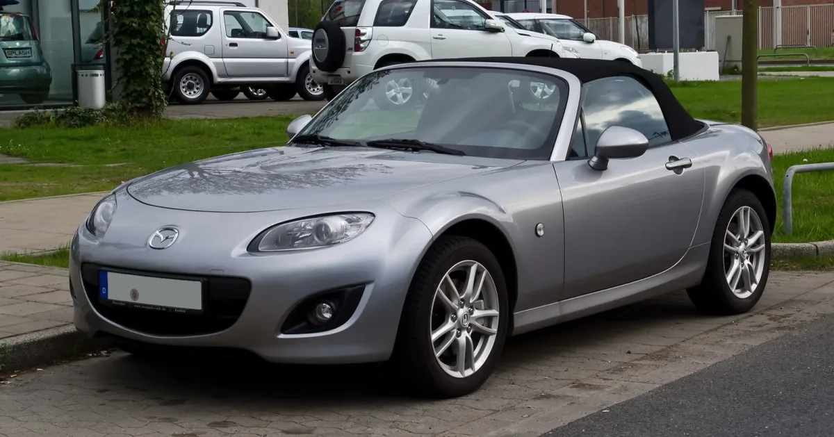 Mazda MX-5 NC po liftingu, z charakterystycznym uśmiechniętym grillem. Egzemplarz z niemieckimi tablicami — dokładnie taki rocznik trafia dziś na polski rynek wtórny.