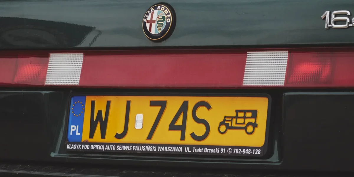 Żółta tablica rejestracyjna pojazdu zabytkowego na Alfie Romeo 164