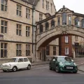 Klasyczny biały Morris Mini-Minor z 1959 roku obok zielonego MINI 60 Years Edition pod mostem na New College Lane w Oksfordzie.