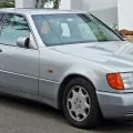 Mercedes 300 SE z pierwszych roczników — jeszcze z szarymi listwami i pomarańczowymi kierunkowskazami, które zniknęły po liftingu 1994 roku. W tej formie W140 debiutował w Genewie i wywołał burzę.