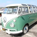 Twarz, od której zaczęła się legenda. Volkswagen Transporter pierwszej generacji — bulik z dzieloną przednią szybą i okrągłym znakiem VW na masce, tu w bogatej odmianie Deluxe z rzędem okienek dachowych.