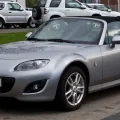 Mazda MX-5 NC po liftingu, z charakterystycznym uśmiechniętym grillem. Egzemplarz z niemieckimi tablicami — dokładnie taki rocznik trafia dziś na polski rynek wtórny.