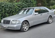 Zadbany W140 potrafi dziś wyglądać jak nowy — pod warunkiem, że poprzedni właściciel traktował go jak Klasę S, a nie jak auto robocze. Ten egzemplarz stoi na nieoryginalnych felgach w stylu AMG.