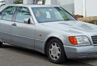 Mercedes 300 SE z pierwszych roczników — jeszcze z szarymi listwami i pomarańczowymi kierunkowskazami, które zniknęły po liftingu 1994 roku. W tej formie W140 debiutował w Genewie i wywołał burzę.