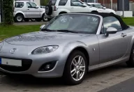 Mazda MX-5 NC po liftingu, z charakterystycznym uśmiechniętym grillem. Egzemplarz z niemieckimi tablicami — dokładnie taki rocznik trafia dziś na polski rynek wtórny.