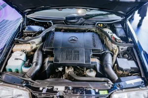 Komora silnika E500 z 1995 roku — pięciolitrowy V8 M119, którego od deski do deski budowało Porsche w Zuffenhausen. To najpotężniejsze i najrzadsze serce gamy 124, a nie typowy widok pod maską: większość typoszeregu jeździła na skromniejszych dieslach i r