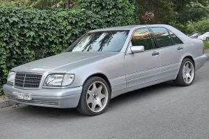 Zadbany W140 potrafi dziś wyglądać jak nowy — pod warunkiem, że poprzedni właściciel traktował go jak Klasę S, a nie jak auto robocze. Ten egzemplarz stoi na nieoryginalnych felgach w stylu AMG.