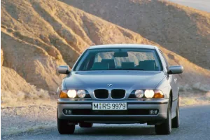BMW 5 Series Sedan E39 w wieczornym świetle na górskiej drodze — oficjalne zdjęcie z retrospektywy BMW Group PressClub.