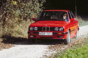 Czerwone E30 na szutrowej drodze, w materiałach prasowych BMW. Egzemplarz w takim stanie trafia dziś do ogłoszeń rzadko, a jego cena zaczyna się tam, gdzie inne się kończą.