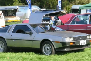 DeLorean DMC-12 z rocznika 1981 z jednym skrzydłem uniesionym w górę. Nielakierowana stal nierdzewna i drzwi otwierane jak u mewy — dokładnie ten obraz kazał twórcom „Powrotu do przyszłości" wybrać właśnie to auto.