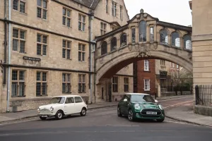 Klasyczny biały Morris Mini-Minor z 1959 roku obok zielonego MINI 60 Years Edition pod mostem na New College Lane w Oksfordzie.