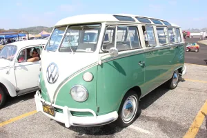 Twarz, od której zaczęła się legenda. Volkswagen Transporter pierwszej generacji — bulik z dzieloną przednią szybą i okrągłym znakiem VW na masce, tu w bogatej odmianie Deluxe z rzędem okienek dachowych.