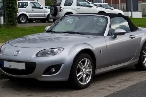 Mazda MX-5 NC po liftingu, z charakterystycznym uśmiechniętym grillem. Egzemplarz z niemieckimi tablicami — dokładnie taki rocznik trafia dziś na polski rynek wtórny.