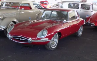 Jaguar E-Type Series 1 z reflektorami schowanymi za szklanymi osłonami — sylwetka, która w 1961 roku zatrzymała dziennikarzy przy barierce.