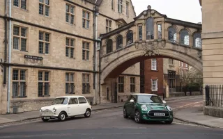 Klasyczny biały Morris Mini-Minor z 1959 roku obok zielonego MINI 60 Years Edition pod mostem na New College Lane w Oksfordzie.