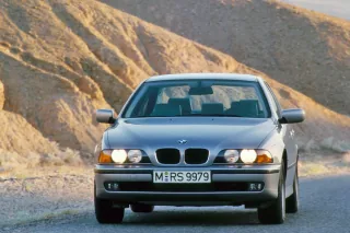 BMW 5 Series Sedan E39 w wieczornym świetle na górskiej drodze – oficjalne zdjęcie z retrospektywy BMW Group PressClub.