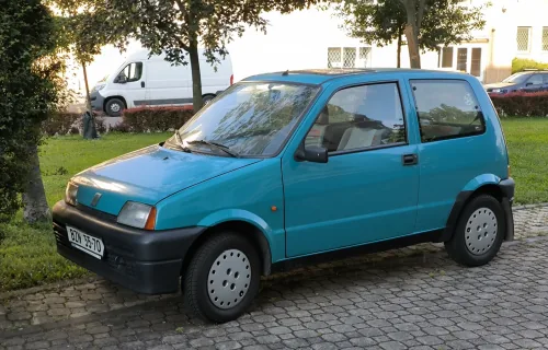 Turkusowy Fiat Cinquecento. Trzy i pół metra kanciastej sylwetki narysowanej w Centro Stile Fiata przez zespół Ermanno Cressoniego. Takich zadbanych sztuk ubywa z każdym rokiem. *fot. Roman Mifek / Wikimedia Commons, CC BY-SA 4.0*