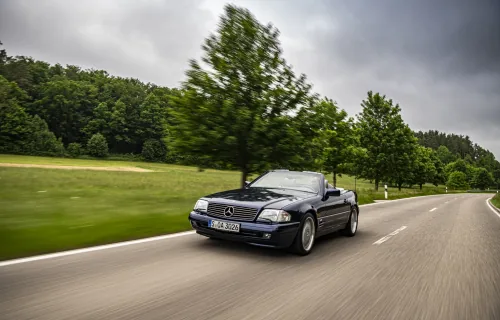 SL 600 R129 w ruchu — sesja Mercedes-Benz Classic z 2021 roku. W trzydziestej rocznicy debiutu V12 marka pokazała ten model jako auto, którym wciąż się jeździ. Nie eksponat. Egzemplarz w drodze.