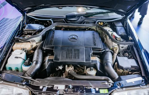 Komora silnika E500 z 1995 roku — pięciolitrowy V8 M119, którego od deski do deski budowało Porsche w Zuffenhausen. To najpotężniejsze i najrzadsze serce gamy 124, a nie typowy widok pod maską: większość typoszeregu jeździła na skromniejszych dieslach i r