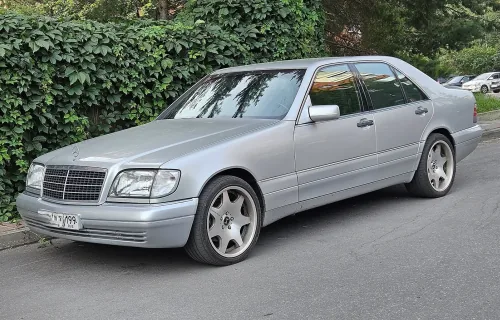 Zadbany W140 potrafi dziś wyglądać jak nowy — pod warunkiem, że poprzedni właściciel traktował go jak Klasę S, a nie jak auto robocze. Ten egzemplarz stoi na nieoryginalnych felgach w stylu AMG.