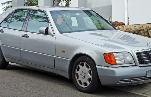 Mercedes 300 SE z pierwszych roczników — jeszcze z szarymi listwami i pomarańczowymi kierunkowskazami, które zniknęły po liftingu 1994 roku. W tej formie W140 debiutował w Genewie i wywołał burzę.