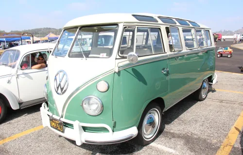 Twarz, od której zaczęła się legenda. Volkswagen Transporter pierwszej generacji — bulik z dzieloną przednią szybą i okrągłym znakiem VW na masce, tu w bogatej odmianie Deluxe z rzędem okienek dachowych.