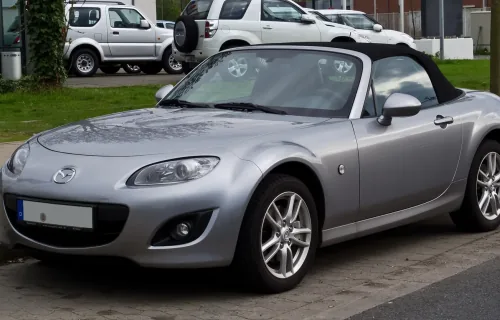 Mazda MX-5 NC po liftingu, z charakterystycznym uśmiechniętym grillem. Egzemplarz z niemieckimi tablicami — dokładnie taki rocznik trafia dziś na polski rynek wtórny.