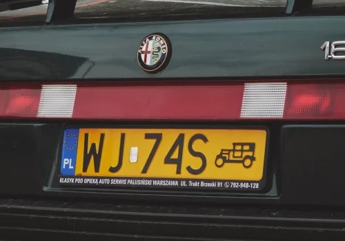Żółta tablica rejestracyjna pojazdu zabytkowego na Alfie Romeo 164