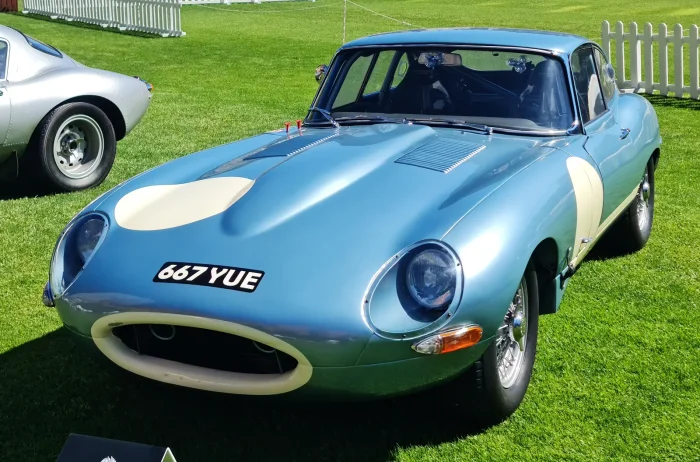 E-Type w specyfikacji wyścigowej — roll cage i wlot na masce zdradzają auto przygotowane na tor. To nie oryginalny Lightweight, lecz kontekst torowego rodowodu modelu.