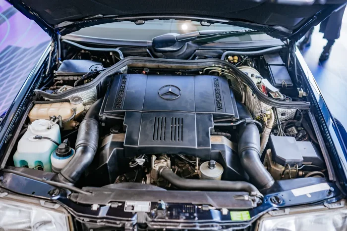 Komora silnika E500 z 1995 roku — pięciolitrowy V8 M119, którego od deski do deski budowało Porsche w Zuffenhausen. To najpotężniejsze i najrzadsze serce gamy 124, a nie typowy widok pod maską: większość typoszeregu jeździła na skromniejszych dieslach i r