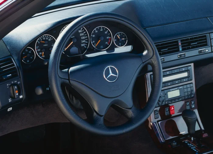 Wnętrze SL 500 MOPF2 — tu wchodzi większość świadomych modyfikacji. CarPlay zamiast oryginalnego COMAND-u, regeneracja motoru soft-top, czasem konwersja R12 → R134a w klimatyzacji. Reszta zostaje jak była.