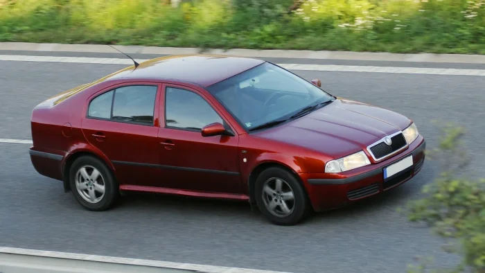 Bordowy liftback złapany w ruchu na czeskiej drodze — okrągłe reflektory i chromowana atrapa to jeszcze wersja sprzed liftingu 2000 roku. Prosta bryła, która nigdy nie próbowała być czymś więcej niż solidnym autem.