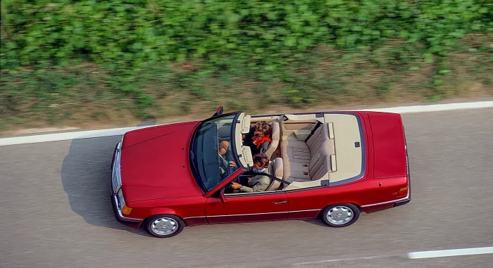 Kabriolet A124 z 1992 roku w ruchu, z opuszczonym dachem — to, po co kupowało się to nadwozie. Wzmocnienia dodane do karoserii dały masę, ale i bezcenną zaletę: A124 jeździ jak całość, a nie jak rozcięte coupé. To właśnie ten egzemplarz, kabriolet, jako o