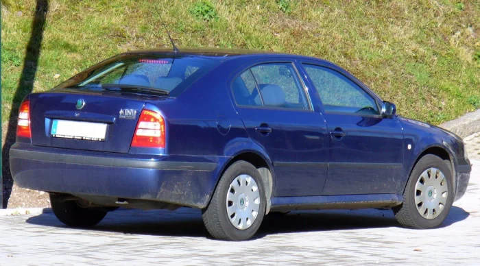 Zakurzony granatowy liftback w wersji Tour — najprostsza i najtańsza odmiana, jaką kupowały tysiące polskich rodzin szukających taniej niezawodności. Tylne lampy zdradzają już rocznik po liftingu.