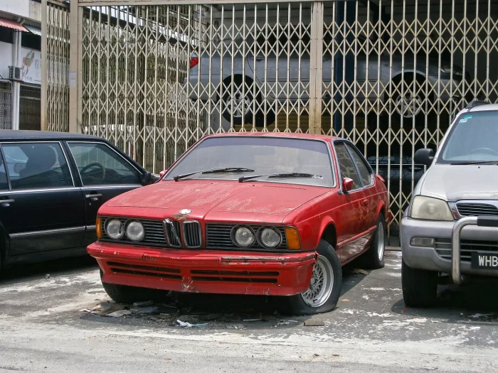 Zapomniane coupé na parkingu w Kuala Lumpur. Rdza zjada E24 od środka — progi i nadkola potrafią być martwe, zanim cokolwiek widać na lakierze.