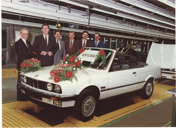 Regensburg, 1989. Sto tysięcy kabrioletów E30 — jubileuszowy egzemplarz w kwiatach i załoga zakładu, która go zbudowała.
