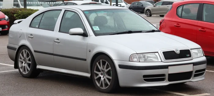 Srebrna vRS na deszczowym parkingu w Anglii — zielony znaczek na atrapie i sportowe felgi zdradzają 1.8 turbo zamknięte w praktycznej bryle liftbacka. Tak Škoda pokazała, że rozsądne auto też może mieć charakter.