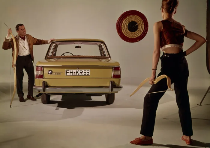 BMW 1500 od tyłu w studio — żółty egzemplarz, para z łukami do łucznictwa