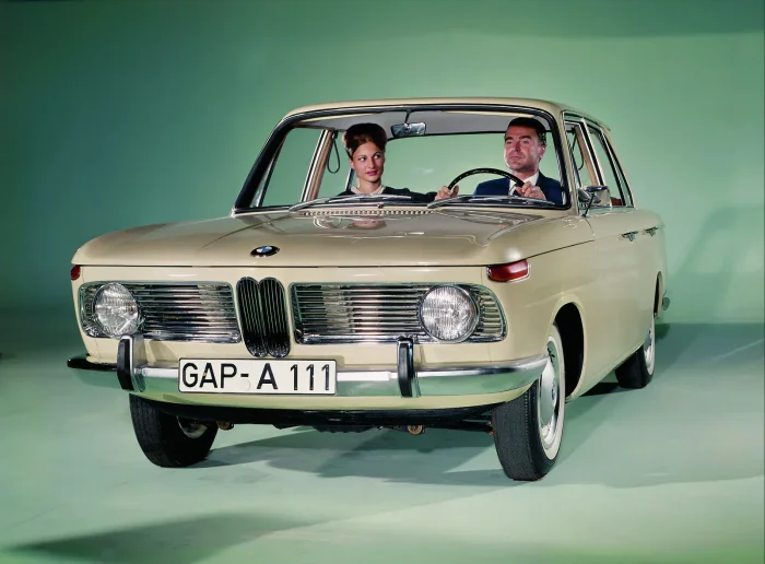 BMW 1500 z przodu na zielonym tle studyjnym z parą w środku