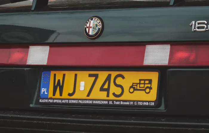 Żółta tablica rejestracyjna pojazdu zabytkowego na Alfie Romeo 164