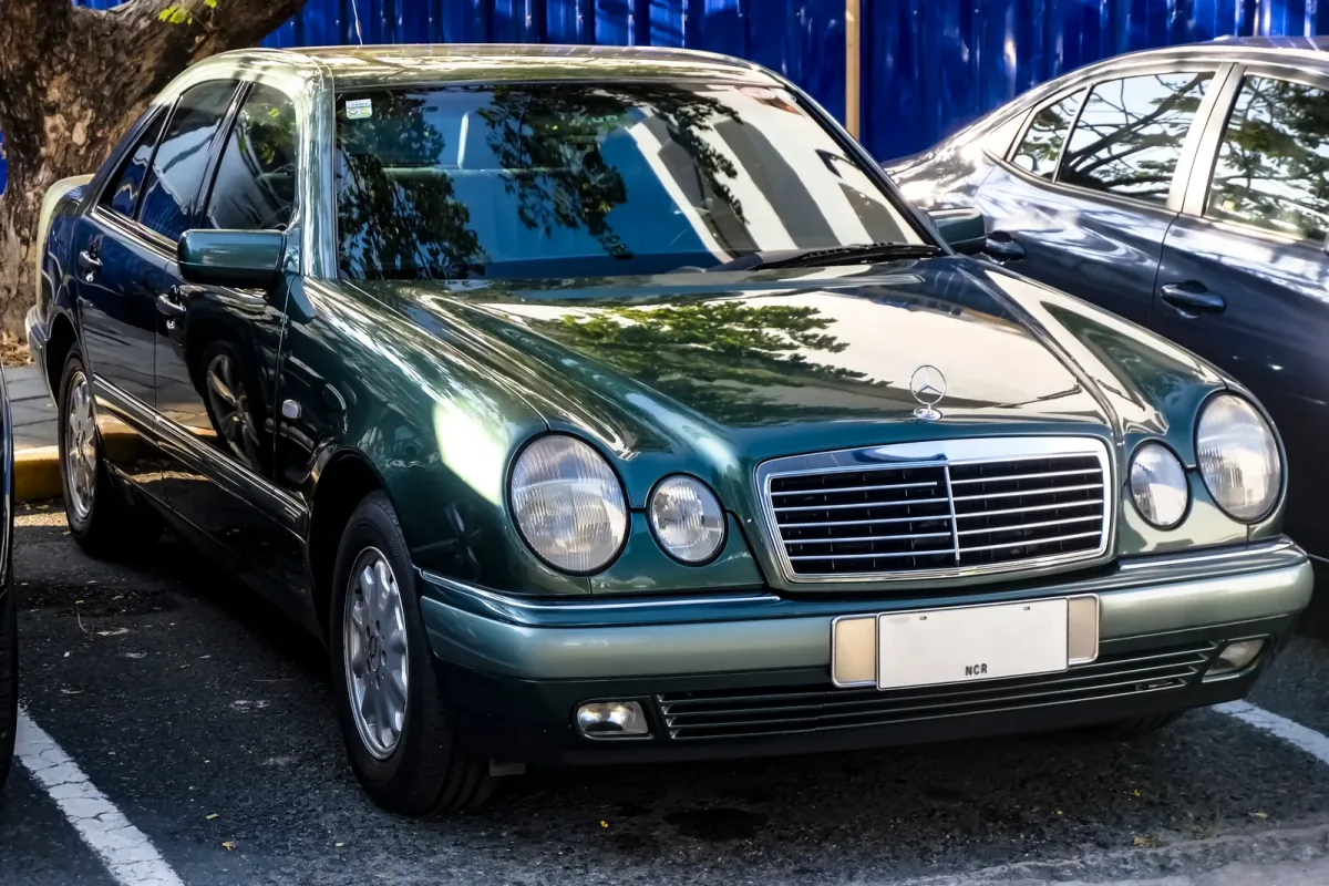 Mercedes E 230 w linii Elegance, egzemplarz pierwszej serii. Cztery owalne reflektory zastąpiły prostokątne klosze W124 i na dekadę stały się twarzą marki. Fot. Ethan Llamas, Wikimedia Commons, CC BY-SA 4.0.