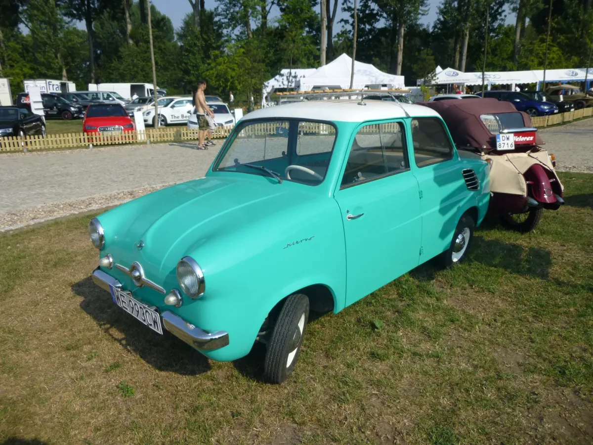 Mikrus MR-300 w turkusowym kolorze z białym dachem na trawie, ujęcie trójćwarte z przodu i lewego boku, na polskich tablicach; w tle zlot zabytkowych pojazdów. Fot. MartinHansV, Wikimedia Commons, licencja CC BY 3.0