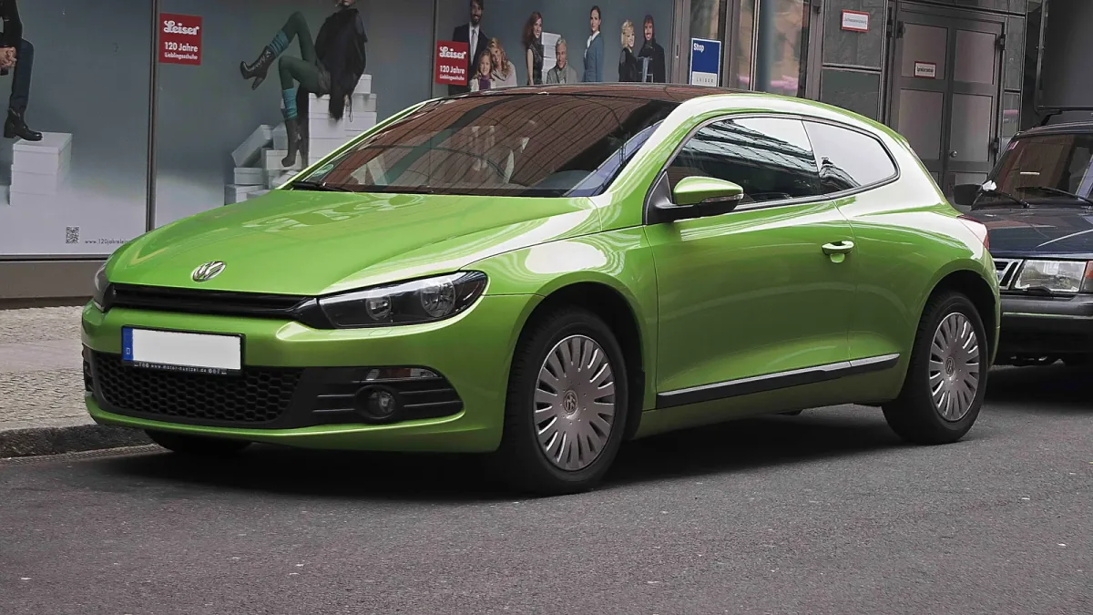 Volkswagen Scirocco III sprzed liftingu w zielonym lakierze Viperngrün — ujęcie 3/4 z przodu, seryjne kołpaki i ciemny dach, egzemplarz zaparkowany przy ulicy.