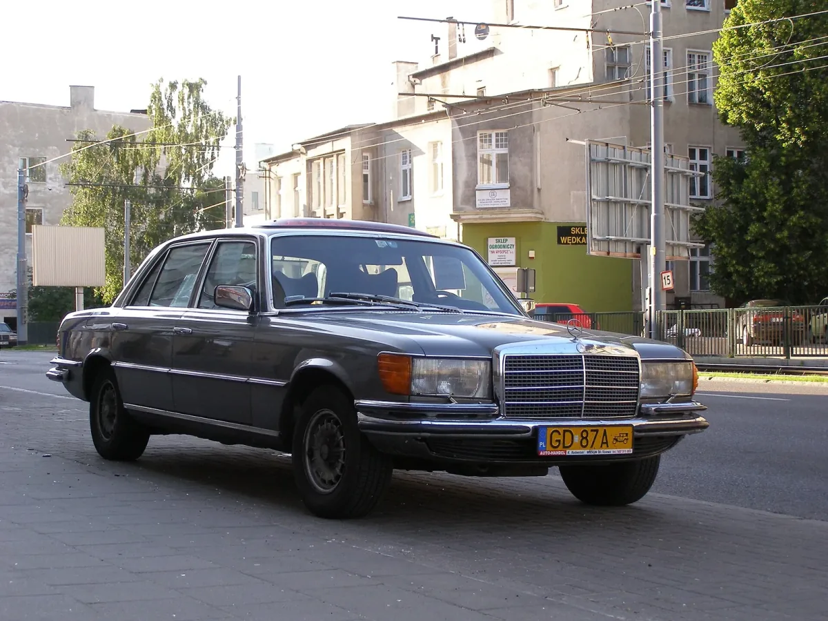 Mercedes-Benz 450 SEL (W116) na ulicy w Gdańsku, z przodu polska żółta tablica zabytkowa GD 87A z piktogramem pojazdu historycznego