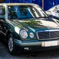 Mercedes E 230 w linii Elegance, egzemplarz pierwszej serii. Cztery owalne reflektory zastąpiły prostokątne klosze W124 i na dekadę stały się twarzą marki. Fot. Ethan Llamas, Wikimedia Commons, CC BY-SA 4.0.