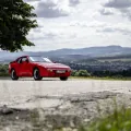 Przód i bok czerwonego Porsche 944 w wersji bazowej. Fot. Porsche AG