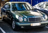 Mercedes E 230 w linii Elegance, egzemplarz pierwszej serii. Cztery owalne reflektory zastąpiły prostokątne klosze W124 i na dekadę stały się twarzą marki. Fot. Ethan Llamas, Wikimedia Commons, CC BY-SA 4.0.
